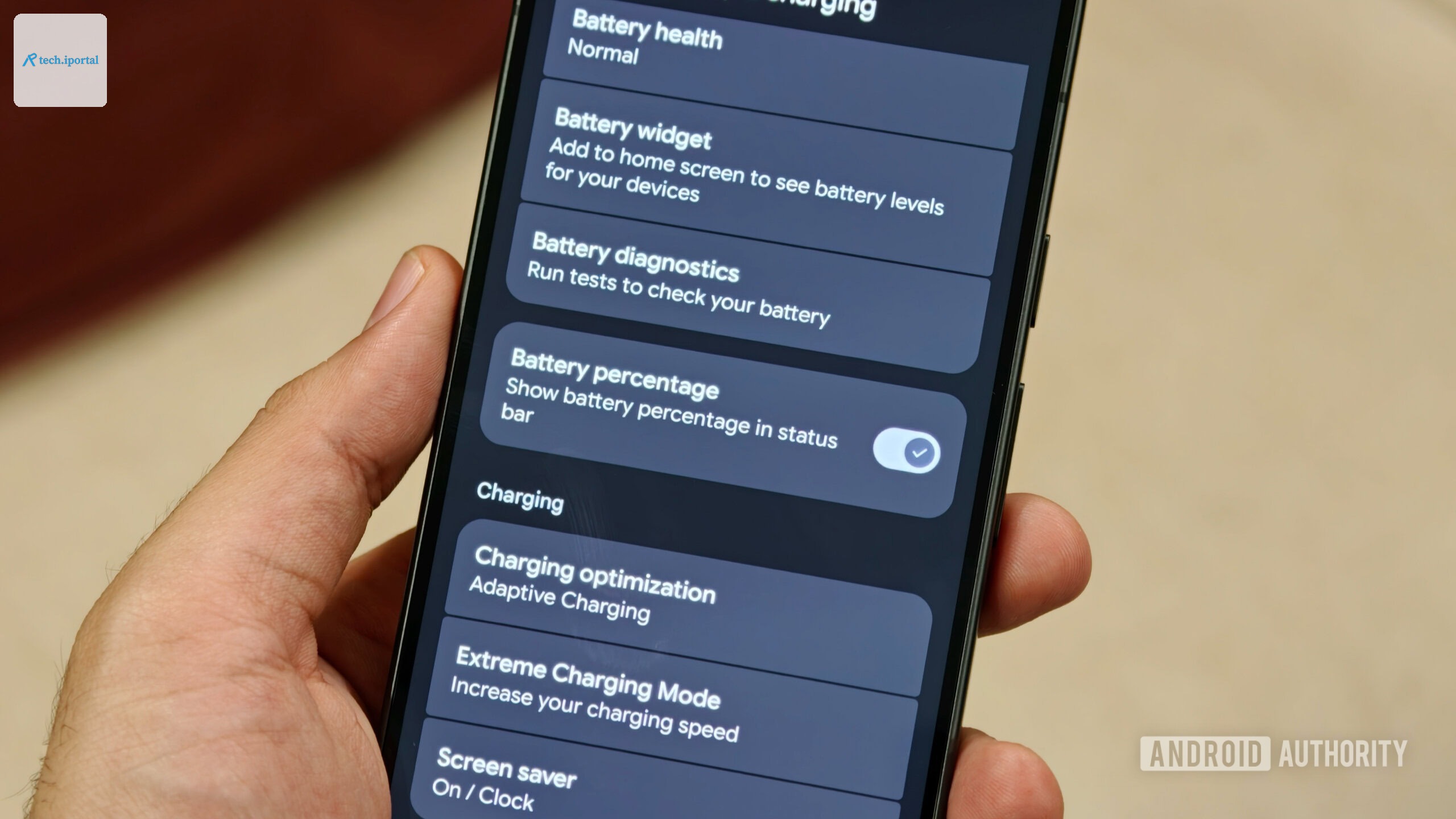 Hand holding Pixel 11 with battery percentage toggle enabled in settings