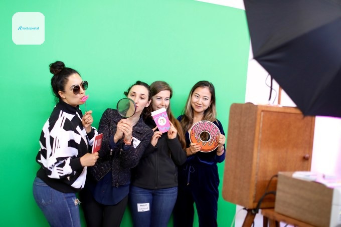 People pose in front of a green screen at TechCrunch Disrupt SF 2019's Women in Tech(Crunch) reception