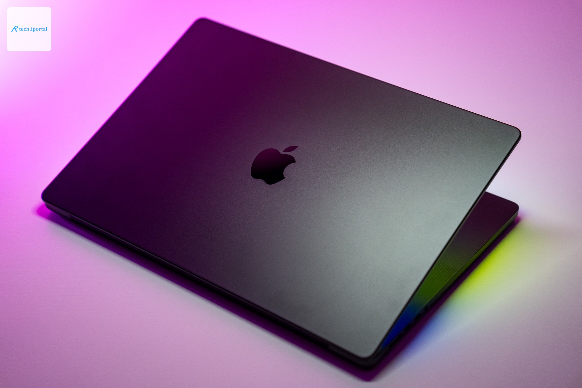 The 16-inch MacBook Pro with M4 Max chip on a white table with pink background.