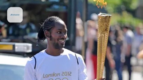 PA Media ason Arday carries the Olympic Flame on the Torch Relay leg between Sutton (London Borough) and Merton (London Borough)