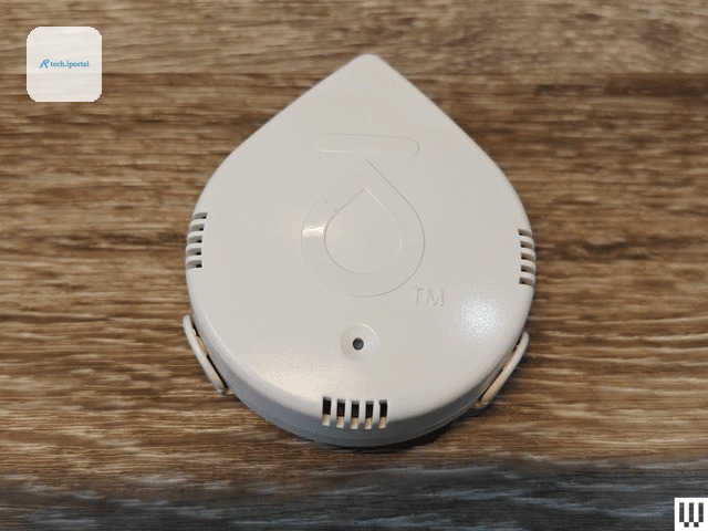 White water droplet shaped device with small slit openings on each side sitting on wooden surface. One of the best water...