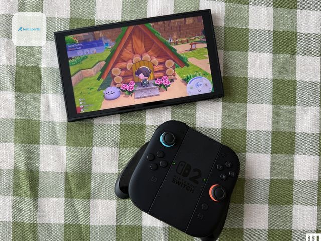 Handheld video game screen beside a controller, both on a green and white striped fabric