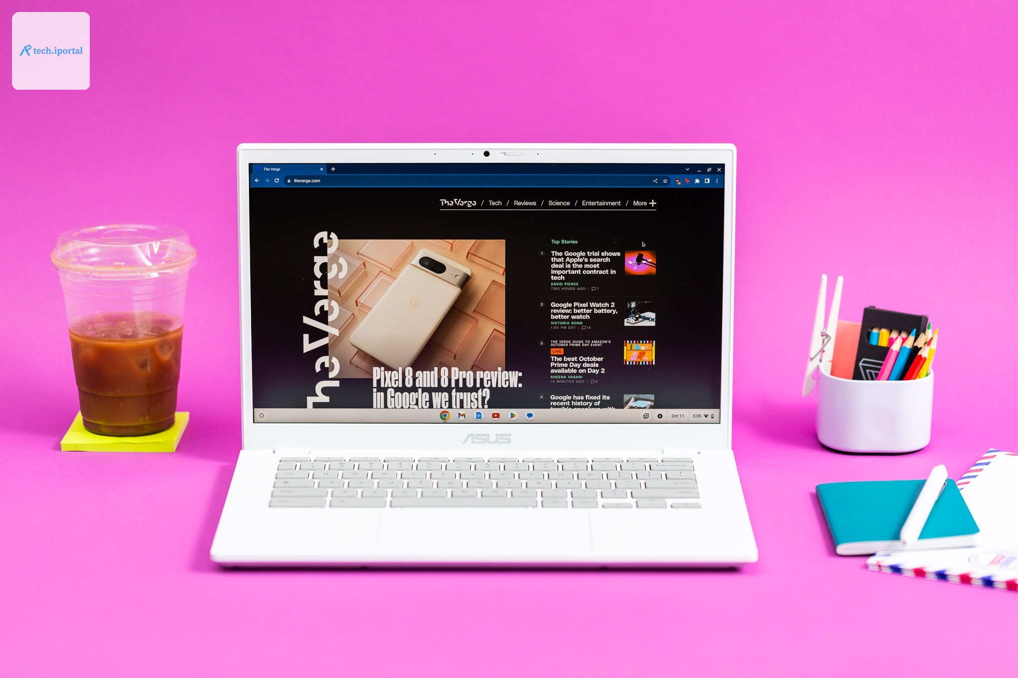 The Asus Chromebook Plus CX34 displaying The Verge homepage between an iced coffee and a cup of colored pencils.