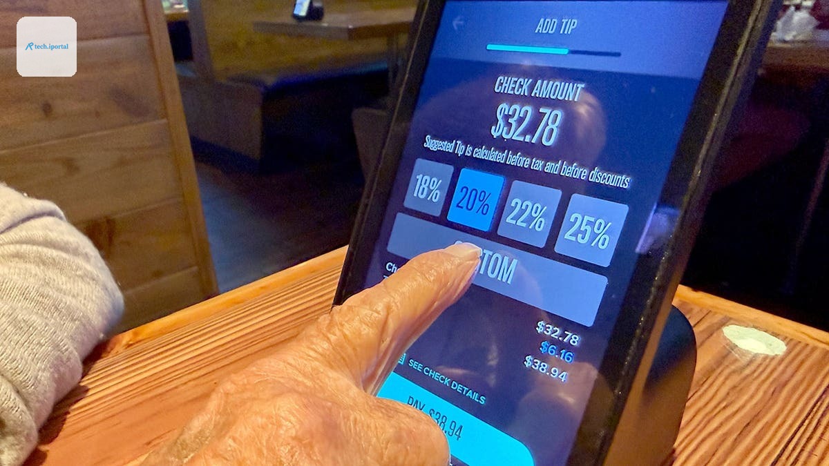 A person choosing a custom tip amount on a Miller's Ale House ziosk at a table.