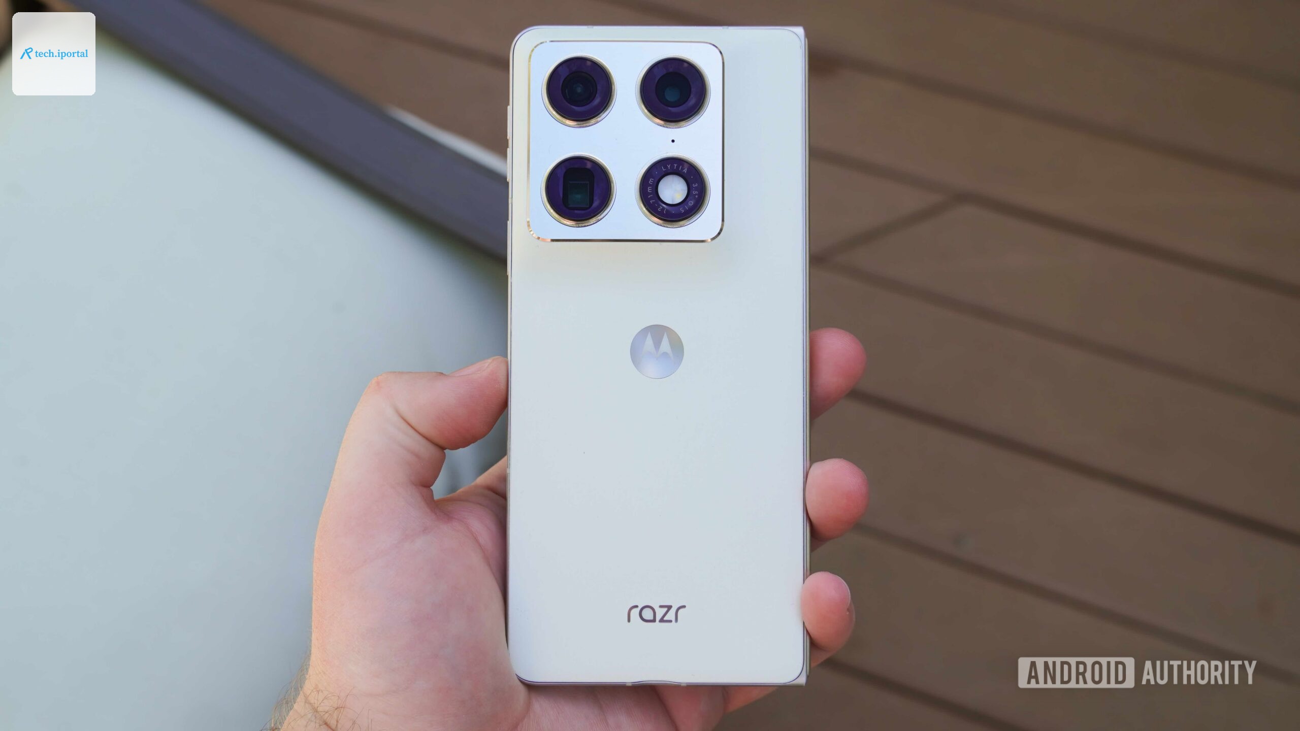 The Razr Fold in Lily White held in the hand.