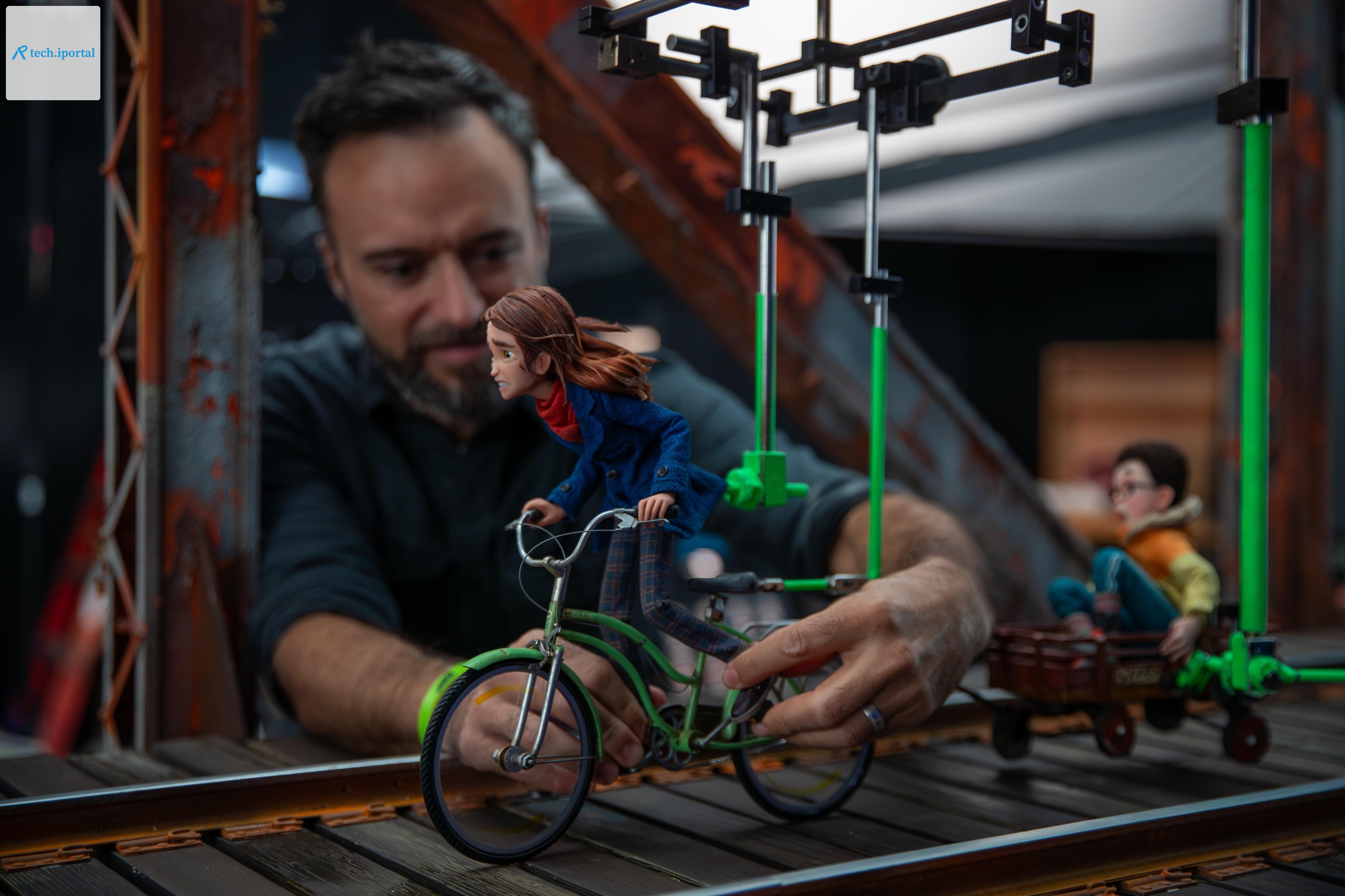 An animator poses a puppet riding a bike for the stop-motion film Wildwood.