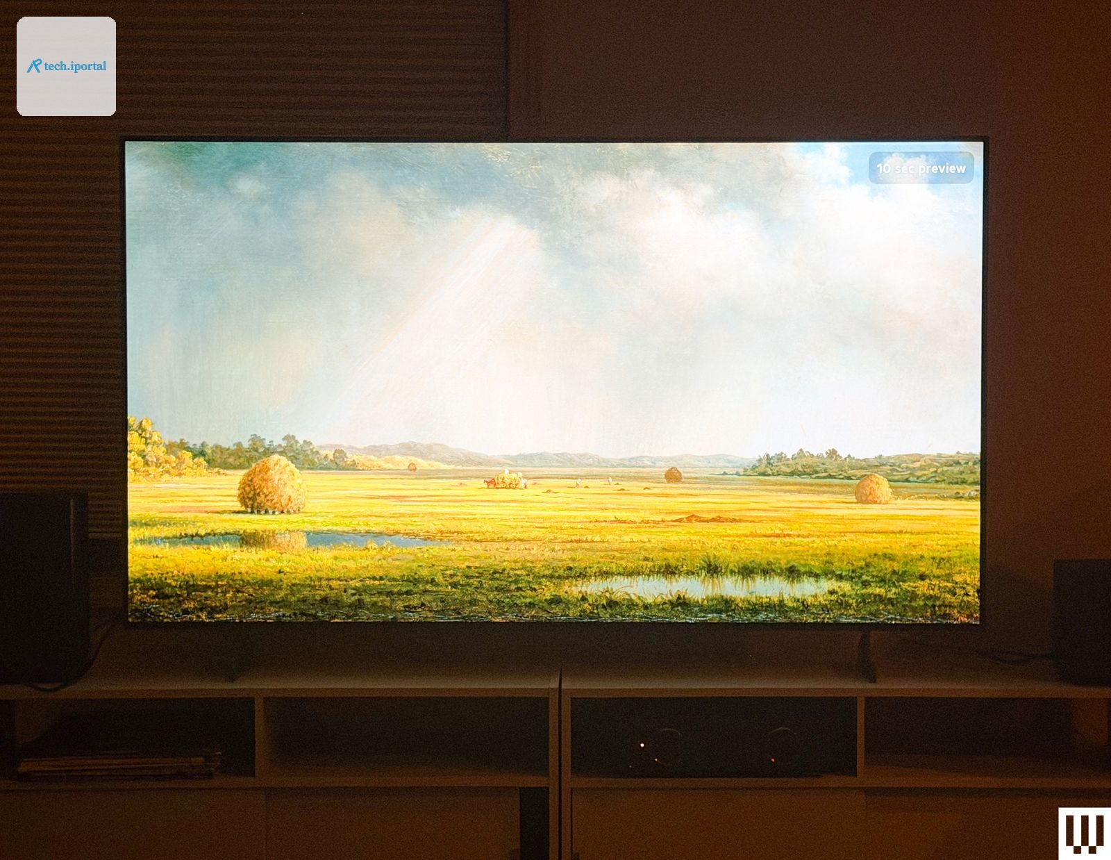 Flatscreen tv in a dark room with the screen showing a grassy landscape