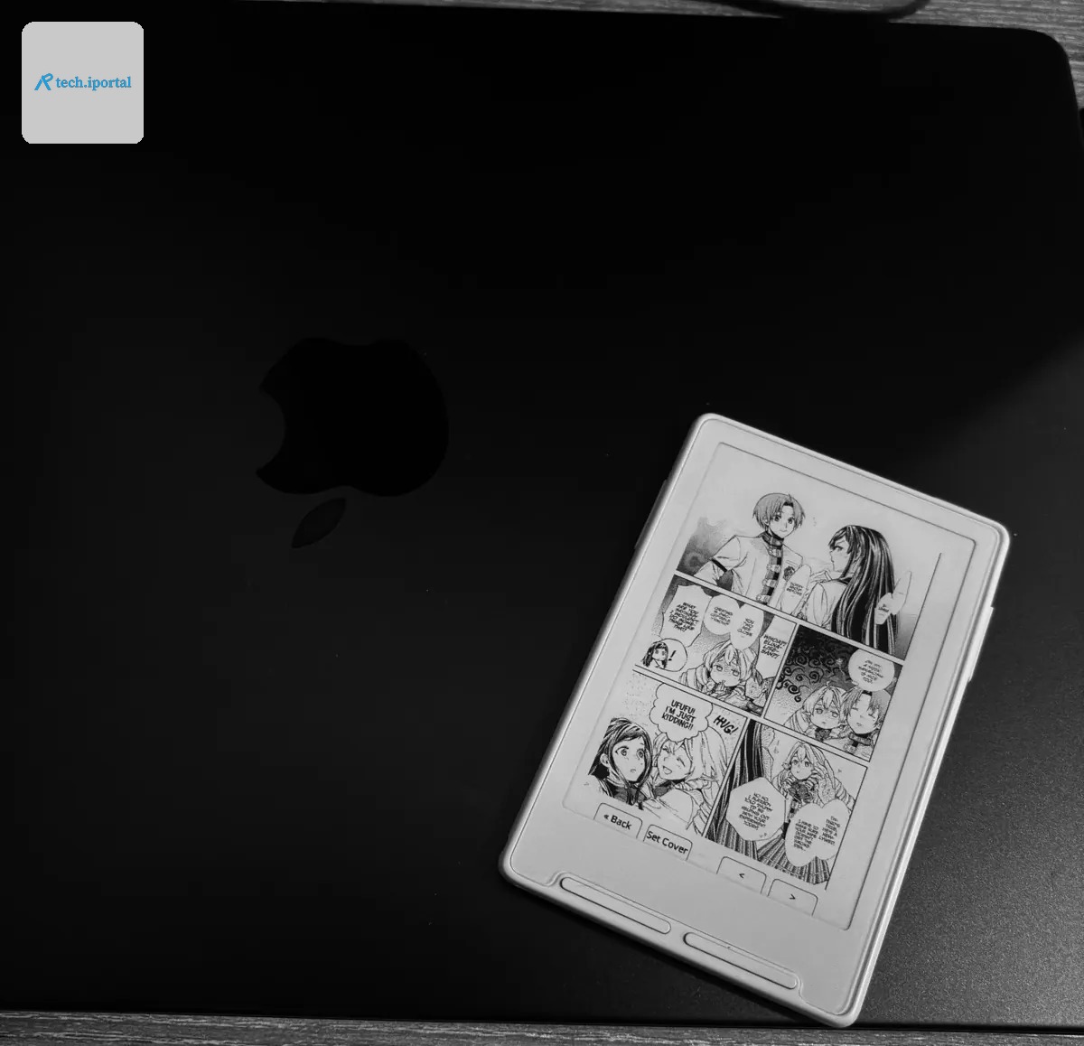 A manga page printed on the Xteink X3, resting on a closed MacBook.