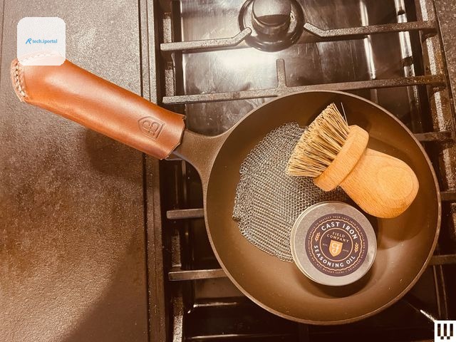 Overhead view of cast iron pan with a leather handle with a brush and tin sitting inside the pan