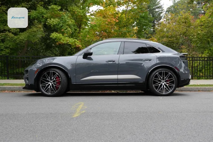 A Porsche Macan sits in front of trees that are changing color.
