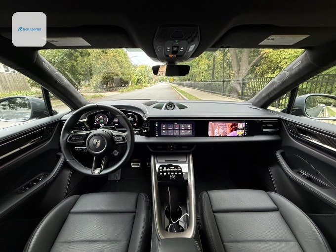 Three screens illuminate the dash of a Macan EV.