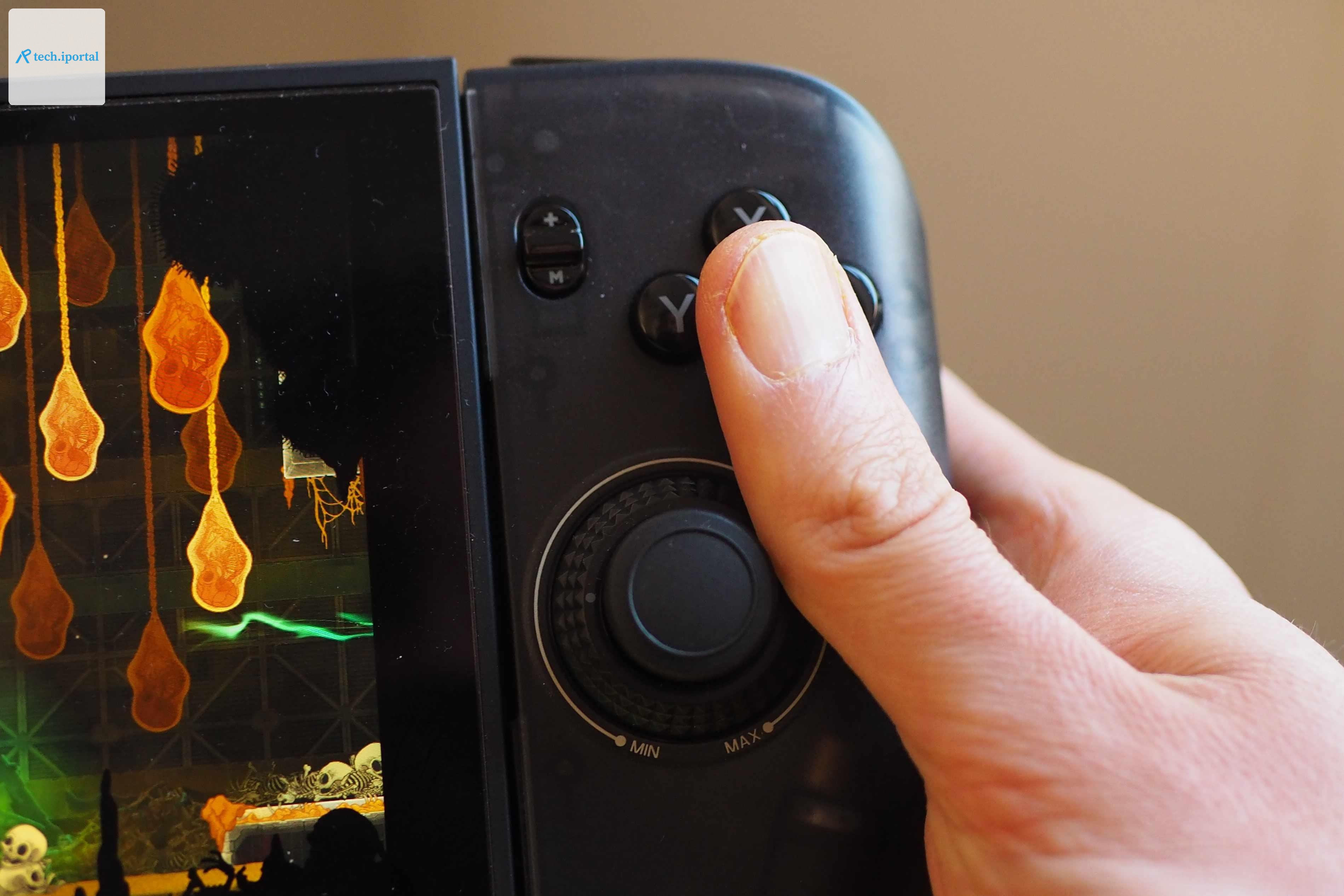 A thumb rests between the right stick and the face buttons in this close-up photo of the Crkd Nitro Deck 2.