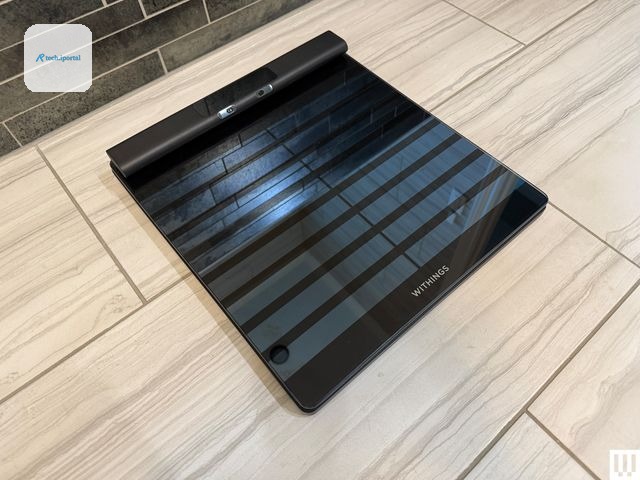 Slim black scale on a tiled floor