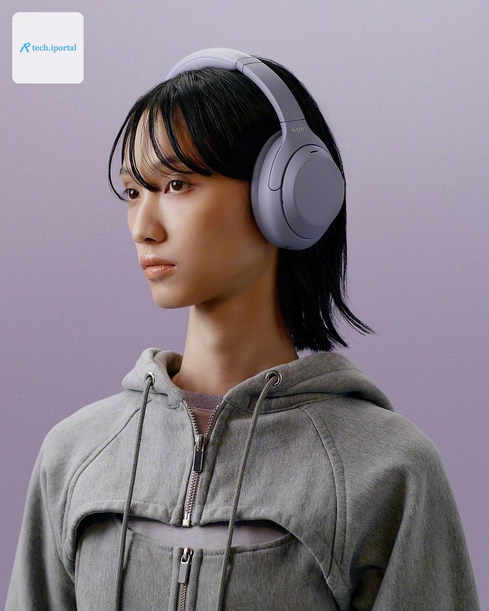 A person in a gray sweatshirt wearing lavender Sony WH-1000XM4C headphones.